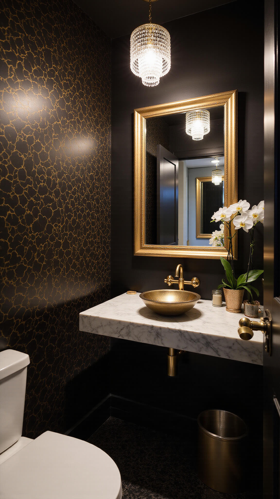 Luxe 5'x7' urban powder room with black and gold geometric wallpaper, crystal pendant light, marble floating vanity with brass hardware, and gilt-framed mirror.