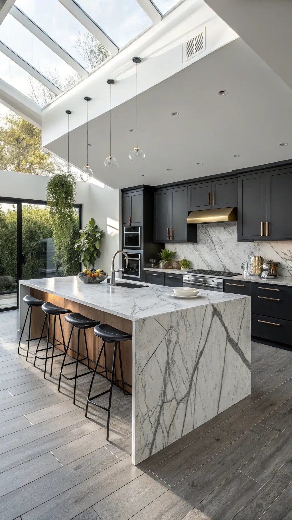 Modern kitchen with matte black cabinetry, stormy gray and white quartzite waterfall island, skylight-lit shadows, integrated appliances, brushed gold fixtures, and artisanal ceramics.