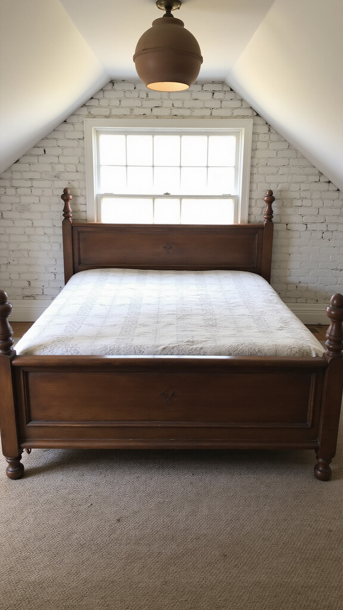 Cozy vintage bedroom with antique oak bed, hand-knotted rug, whitewashed brick wall, and sloped ceiling in soft twilight glow.