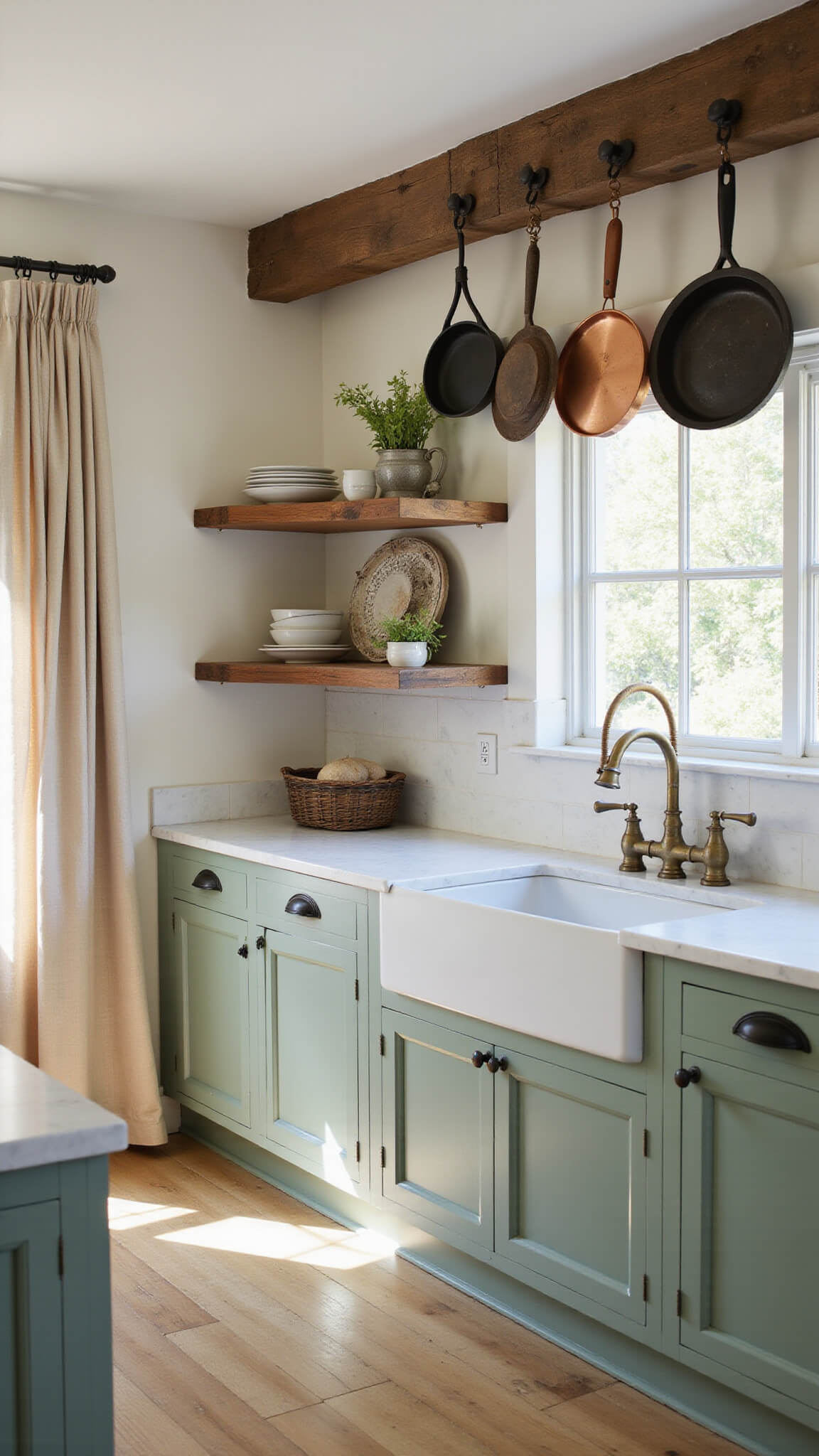 Sunlit farmhouse kitchen with sage green cabinets, aged brass fixtures, and vintage decor, captured from a low corner angle showing cabinet hardware detail and open shelving.