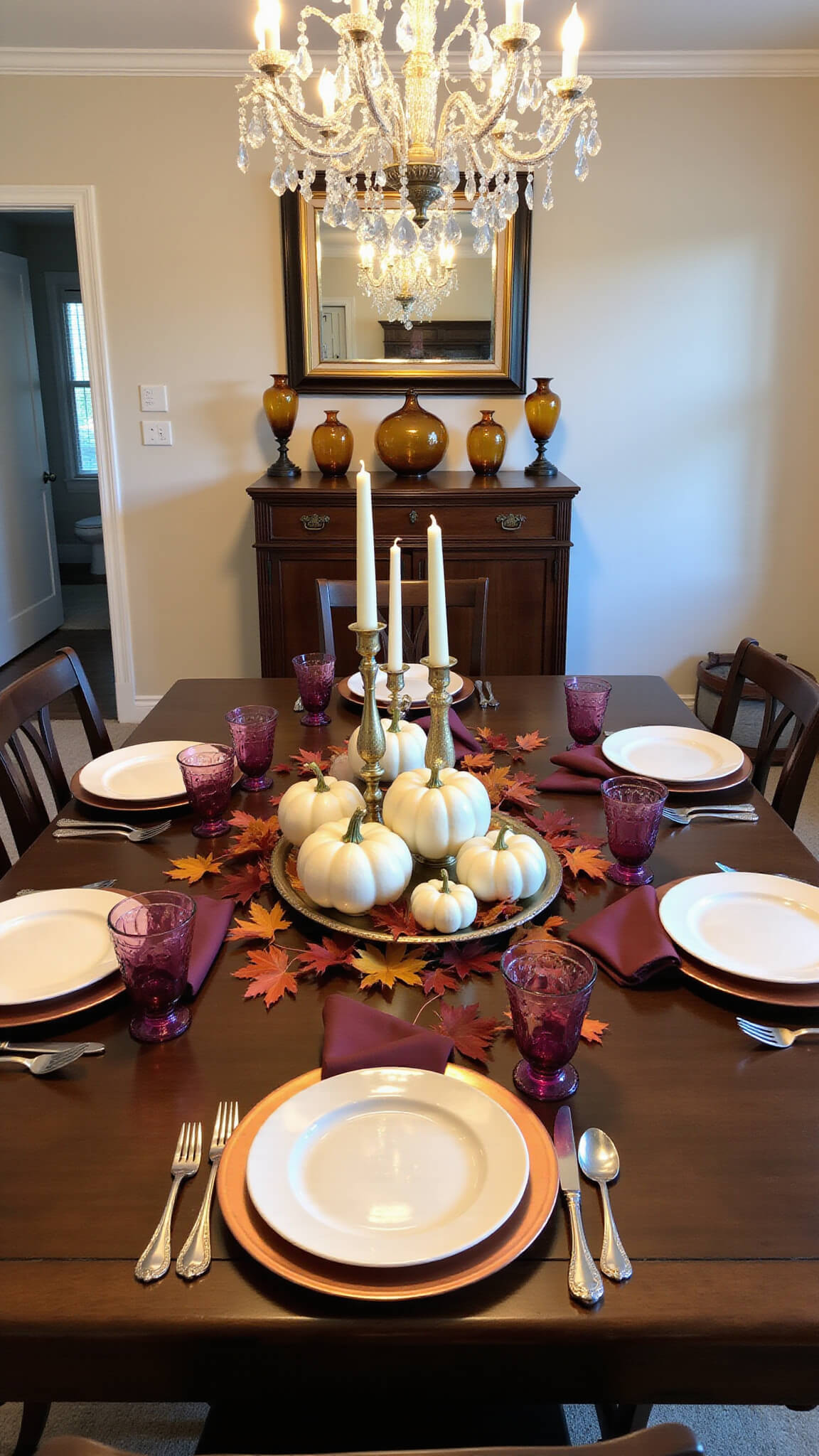 Formal dining room at twilight with dark walnut table set with copper chargers, burgundy linens, ivory stoneware, and white ceramic pumpkin centerpiece surrounded by brass candlesticks and maple leaves.