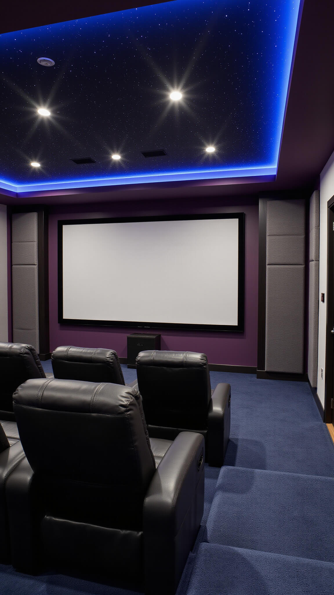 Luxury home theater with tiered black leather seating, 120-inch screen, starfield ceiling, and ambient LED lighting in a dark, acoustically treated room.